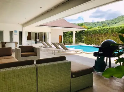 a living room with chairs and a swimming pool at Baan Lalle in Ao Nang Beach