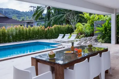 a patio with a table and chairs next to a swimming pool at Baan Lalle in Ao Nang Beach