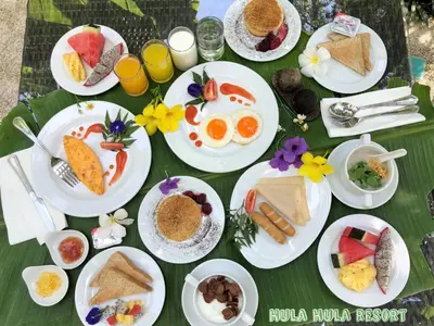 a green table with plates of food on it at HULA HULA RESORT l truly tropical and fun wellness in Ao Nang Beach