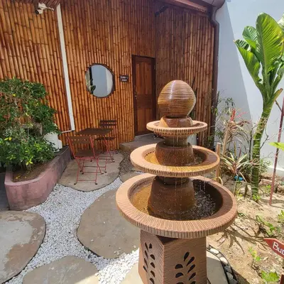 a bird bath sitting on top of a fountain in a yard at Namphung Phuket Boutique Resort in Rawai Beach