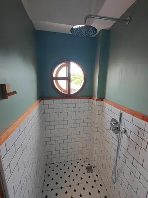 a bathroom with a window and a tiled shower at Namphung Phuket Boutique Resort in Rawai Beach