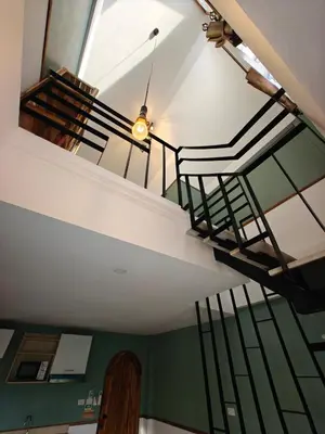a spiral staircase in a room with green walls at Namphung Phuket Boutique Resort in Rawai Beach