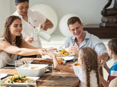 a family eating a meal at a dining table at Sammasan Seaview Villa by Elite Havens in Surin Beach