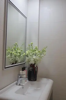 a bathroom sink with a vase with flowers in it at Sun Sea Sand Patong in Patong Beach