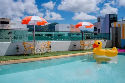 a pool with a rubber duck in the water with umbrellas at Sun Sea Sand Patong in Patong Beach