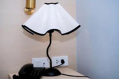 a lamp sitting on a desk next to a telephone at Sun Sea Sand Patong in Patong Beach