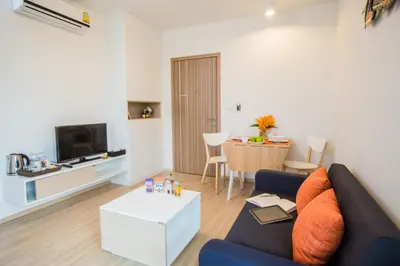 a living room with a couch and a table at Connext Residence Phuket in Phuket Town