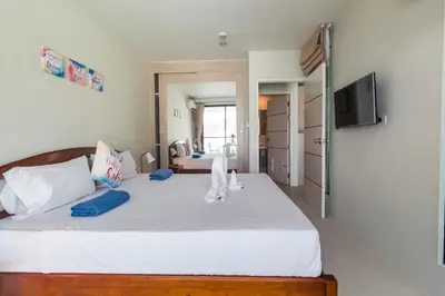 a bedroom with a large white bed and a television at Apartments at The Bliss Condo by Lofty in Patong Beach