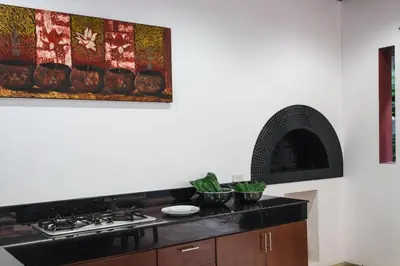 a kitchen with a stove and a painting on the wall at Frangipani pool villa - garden, BBQ & maid in Nai Harn Beach