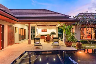 a house with a swimming pool in the backyard at Frangipani pool villa - garden, BBQ & maid in Nai Harn Beach