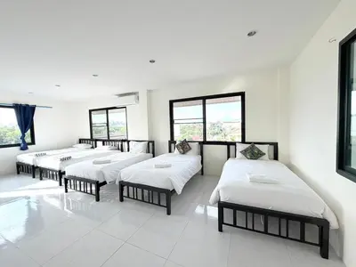 a row of beds in a room with windows at KT Hotel Airport in Nai Yang Beach