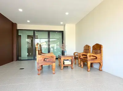 three wooden chairs and a table in a room at KT Hotel Airport in Nai Yang Beach