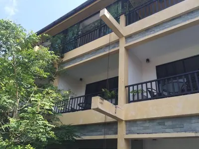 an external view of a building with balconies and trees at B Happy Resort - SHA ExtraPlus in Kamala Beach