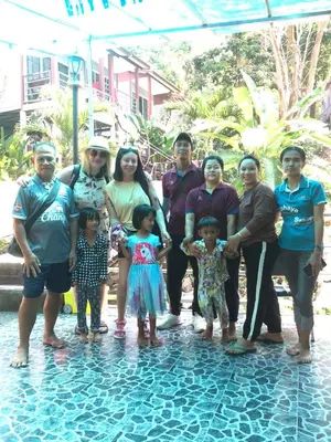 a family posing for a picture next to a pool of water at Sea View Bungalow in Phi Phi Don