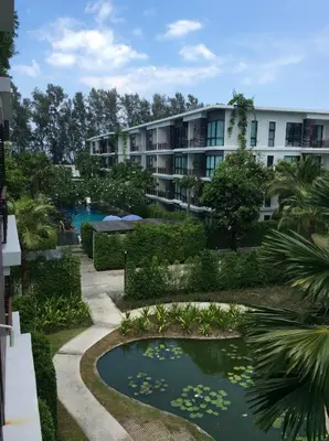 a resort with a pond in front of a building at The Title by Eeri in Rawai Beach