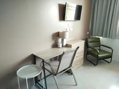 a room with a desk and a chair and a table at In Phuket House in Phuket Town