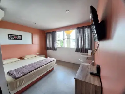 a bedroom with a bed and a flat screen tv at In Phuket House in Phuket Town