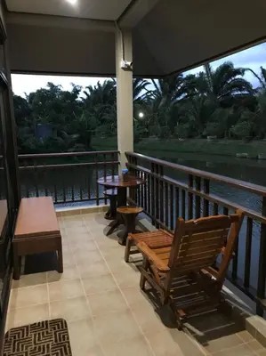 a balcony with benches and tables and a view of the water at Lantala Residence in Natai Beach
