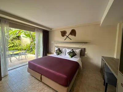 a bedroom with a large bed and a balcony at Sakoo Valley Naithon Beach in Nai Thon Beach