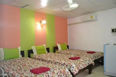 two beds in a room with green and colorful walls at Sweet Home Patong in Patong Beach
