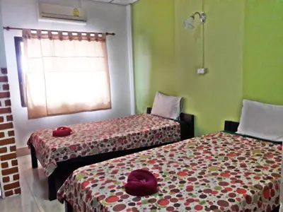 two beds in a room with green walls at Sweet Home Patong in Patong Beach