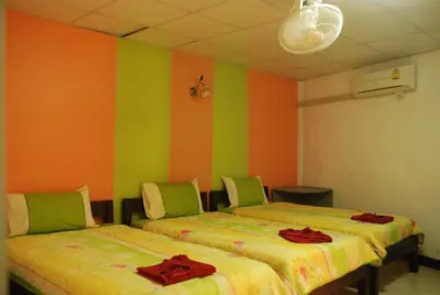 two beds in a room with green and orange walls at Sweet Home Patong in Patong Beach