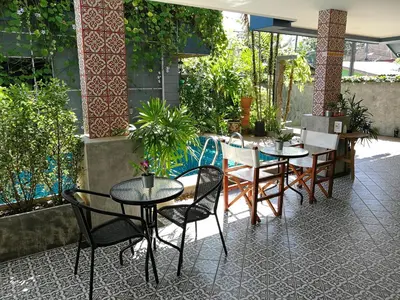 a patio with tables and chairs in a restaurant at The Umbrella House in Kamala Beach