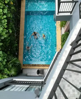 two people swimming in a swimming pool at The Umbrella House in Kamala Beach