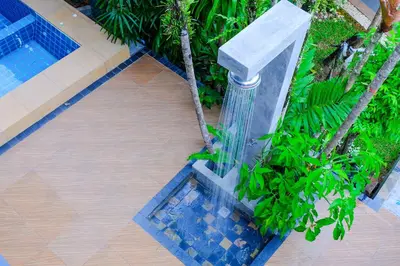 a water fountain next to a swimming pool at The Umbrella House in Kamala Beach