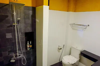 a bathroom with a shower and a toilet at The Umbrella House in Kamala Beach
