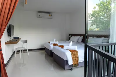 a bedroom with a bed and a balcony at The Umbrella House in Kamala Beach