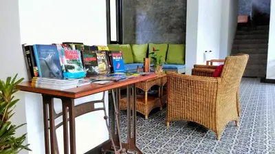 a table with books on it with chairs at The Umbrella House in Kamala Beach