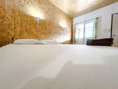 a white bed in a room with a wall at Lux Guesthouse in Phi Phi Don