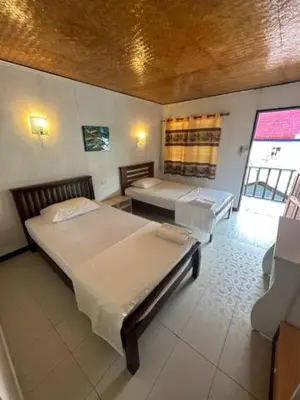 a bedroom with two beds and two tables in it at Lux Guesthouse in Phi Phi Don