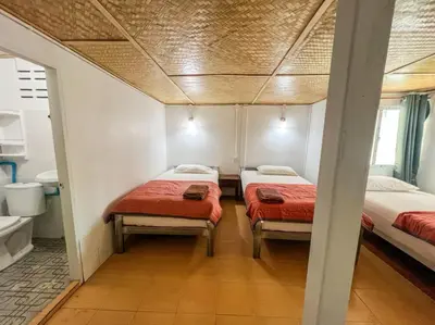 two beds in a small room with a bathroom at Lux Guesthouse in Phi Phi Don