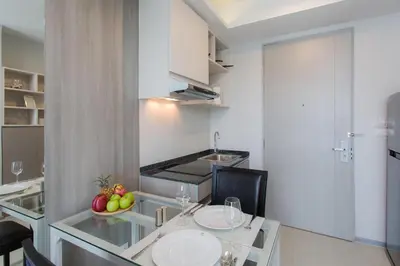 a kitchen with a table with a bowl of fruit on it at 6th Avenue Surin Beach - Official Account in Surin Beach
