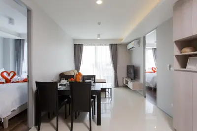 a room with a dining table and a bedroom at 6th Avenue Surin Beach - Official Account in Surin Beach