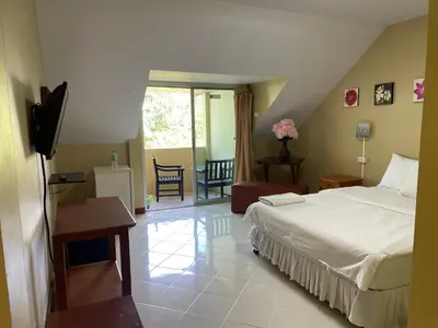 a bedroom with a bed and a television in a room at Nawaporn Place in Phuket Town