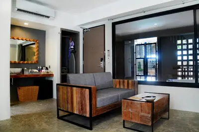 a living room with a chair and a table at Deevana Krabi Resort in Ao Nang Beach