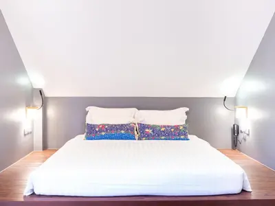 a bedroom with a white bed with two pillows at Deevana Krabi Resort in Ao Nang Beach