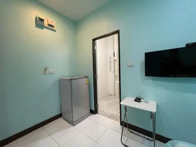 a bathroom with a refrigerator and a television on the wall at Phuket Best Travel in Nai Yang Beach