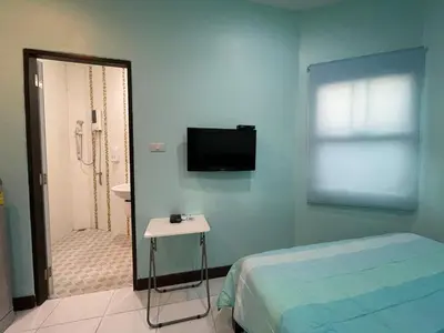 a bedroom with a bed and a television on the wall at Phuket Best Travel in Nai Yang Beach