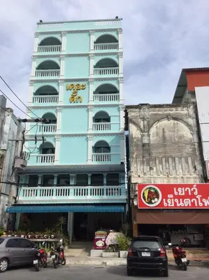 a tall blue building with a sign on it at The Duck in Phuket Town