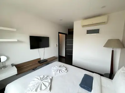 a hotel room with a bed and a flat screen tv at AP Grand Residence by Lofty in Kamala Beach
