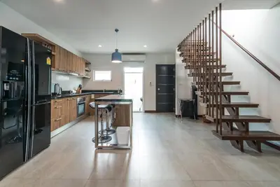 a kitchen with a spiral staircase in a house at AP Grand Residence by Lofty in Kamala Beach