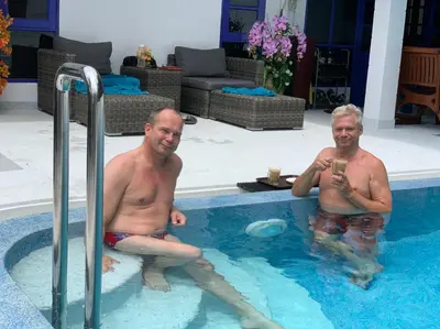 two men are sitting in a swimming pool at Phuket Gay Homestay in Kathu