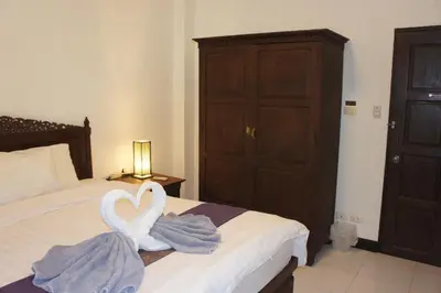 a bedroom with two swans towels on a bed at Phuket Gay Homestay in Kathu