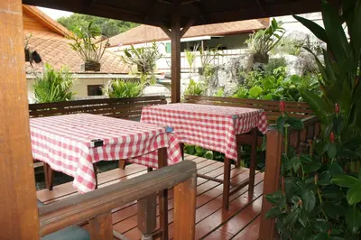 two tables with red and white checkered cloth on a deck at Phuket Gay Homestay in Kathu