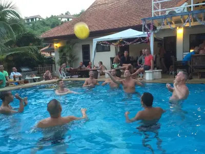 a group of men playing with a ball in a swimming pool at Phuket Gay Homestay in Kathu