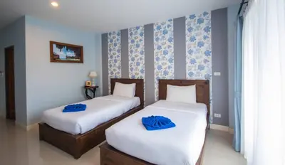two beds in a room with blue towels on them at Krabi Lighthouse @ Aonang in Ao Nang Beach